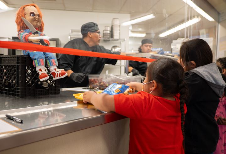 A group of students with trays in cafeteria line getting their meals..