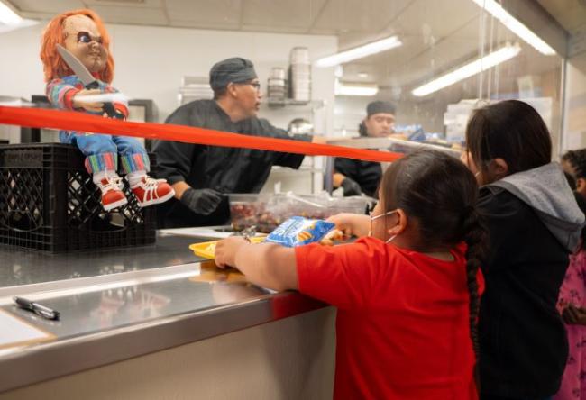 A group of students with trays in cafeteria line getting their meals..